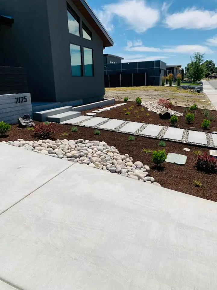 New river rock and bark beds at a modern home